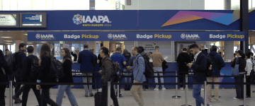 People wearing dark clothing stand in line to grab their entry badge at IAAPA Expo Europe in Amsterdam